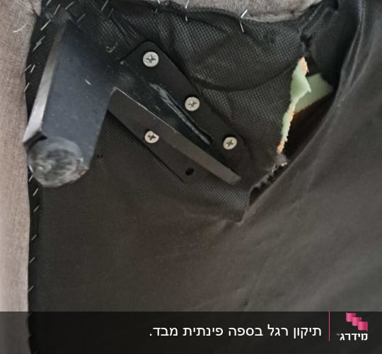 יד מחזיקה ריפוד ספה עם קרע בחלק התחתון